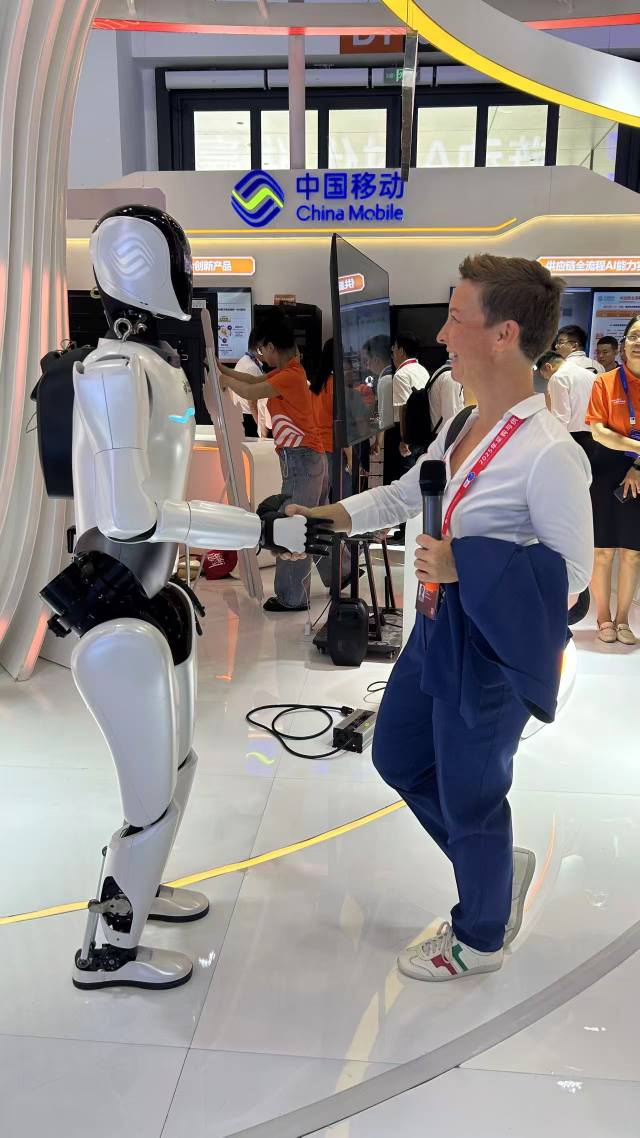 Dorka Nagy-Józsa shaking hands with robot in China
